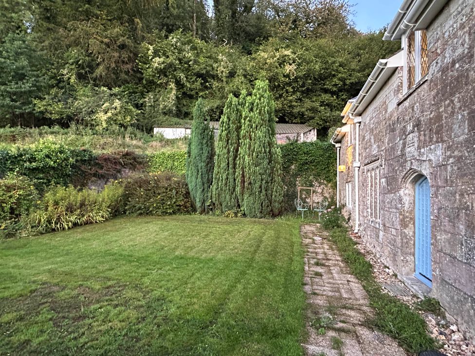 A garden with trees and a pathway at Hole House in Branscombe