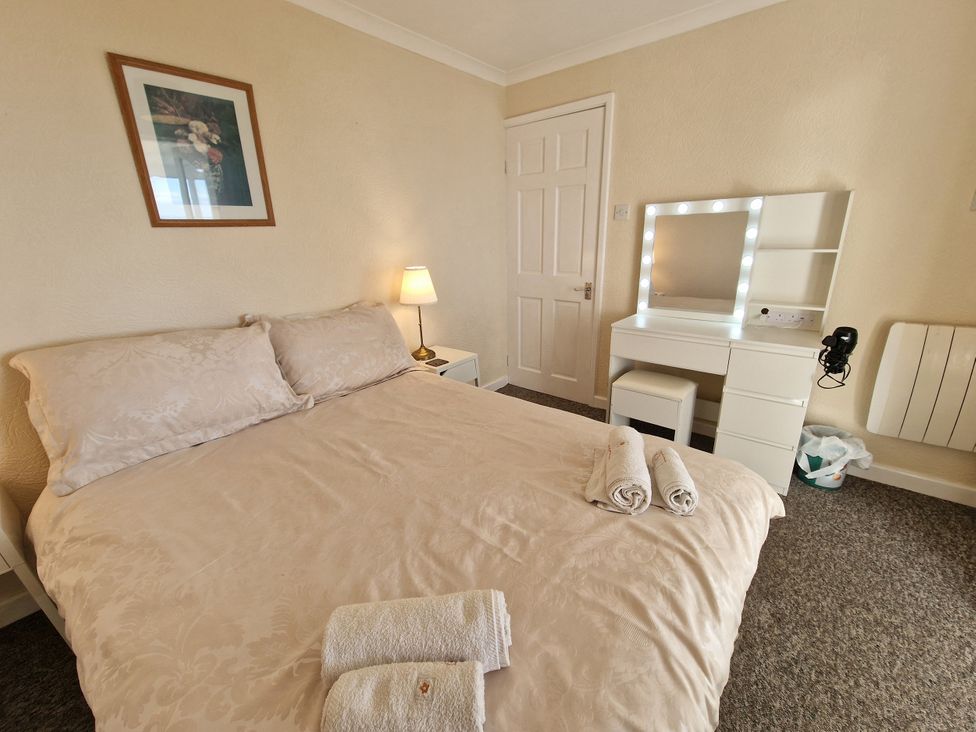 A bedroom with a bed and a dresser at Woodland Roost in Barmouth