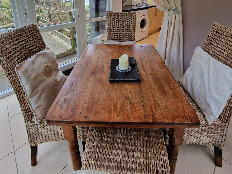 A dining room with a wooden table and chairs at Woodland Roost in Barmouth