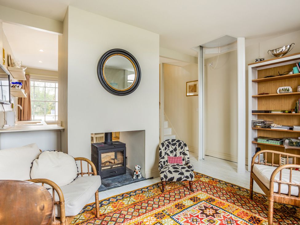 A living room with a fireplace and bookshelf at 8 Mariners Terrace Chichester