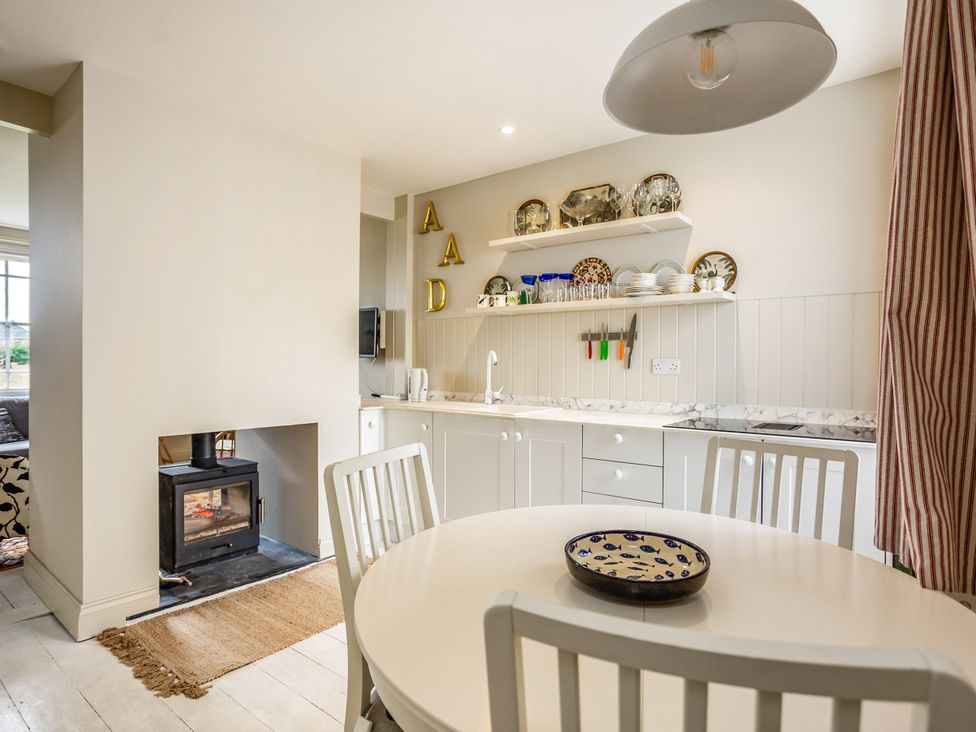 A kitchen with a table and chairs at 8 Mariners Terrace in Chichester