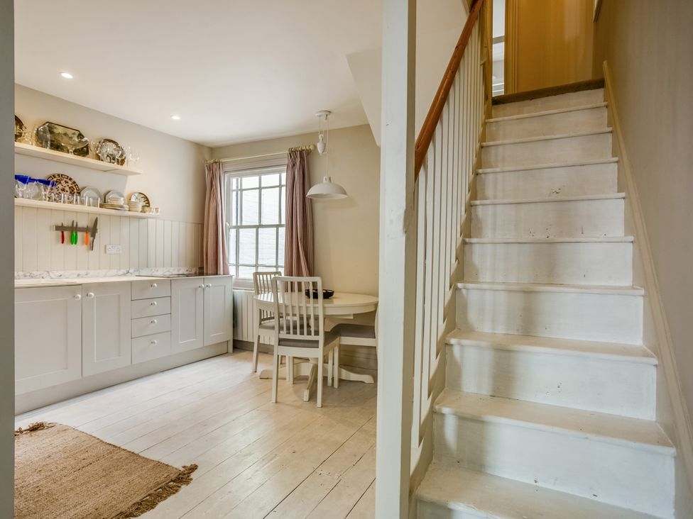 A kitchen with a table and chairs at 8 Mariners Terrace in Chichester