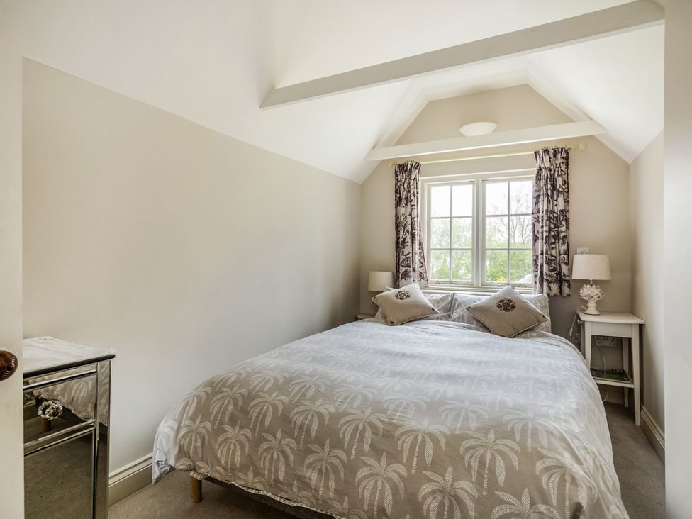A bedroom with a bed, side tables, and curtains at 8 Mariners Terrace, Chichester