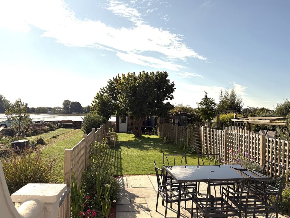 A garden with a table and chairs surrounded by greenery at 8 Mariners Terrace in Chichester