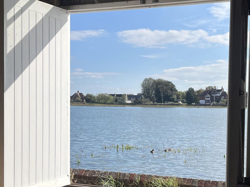 A view of water and houses from an open door at 8 Mariners Terrace in Chichester
