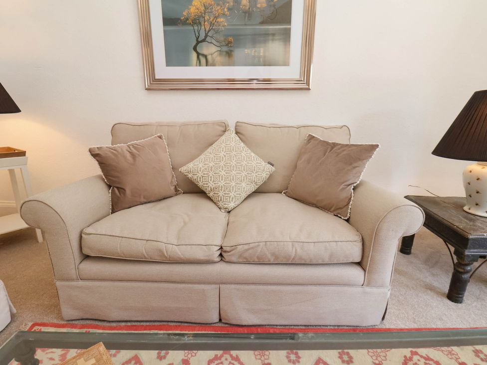 Beige sofa with three cushions and two side tables with lamps in a living room at Flat 1 in Scarborough
