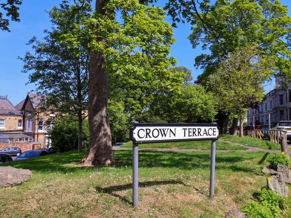 A street sign reading Crown Terrace with trees and buildings in the background at Flat 1 in Scarborough