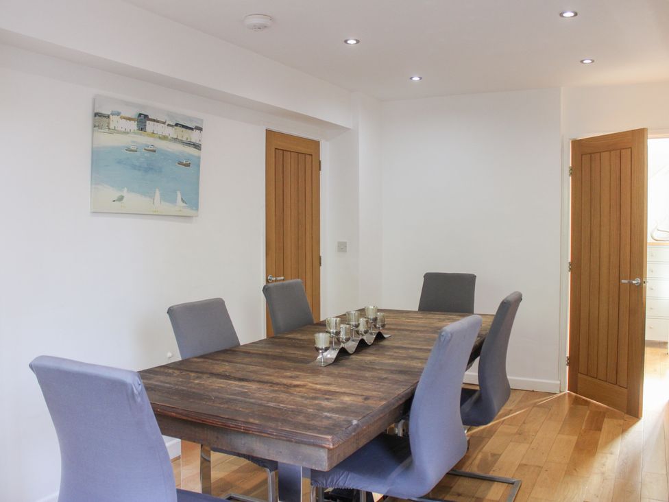 A dining room with a wooden table and chairs at The Old Police House in Salcombe