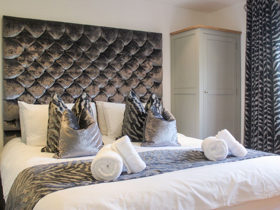 A bedroom with a bed and storage cabinet at Old Police House Salcombe