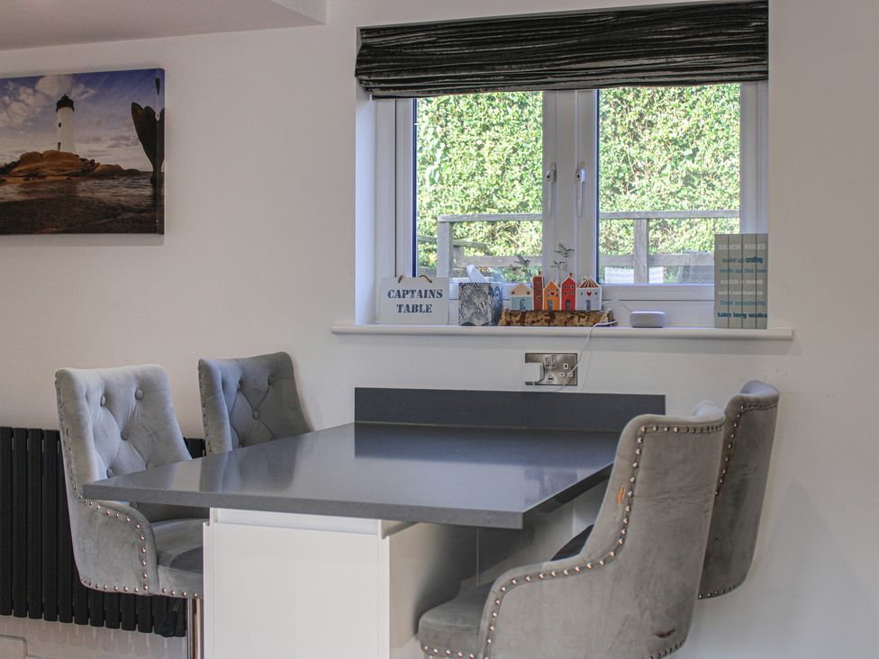 A kitchen with a table and chairs at Old Police House Salcombe