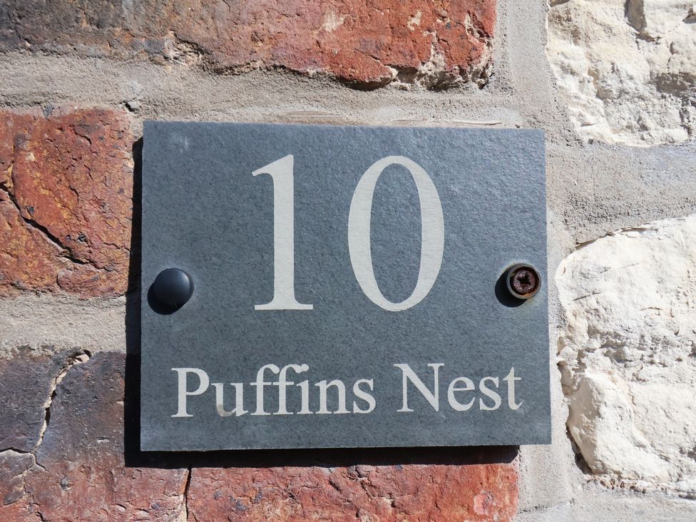 A house number sign on a wall at Puffin's Nest