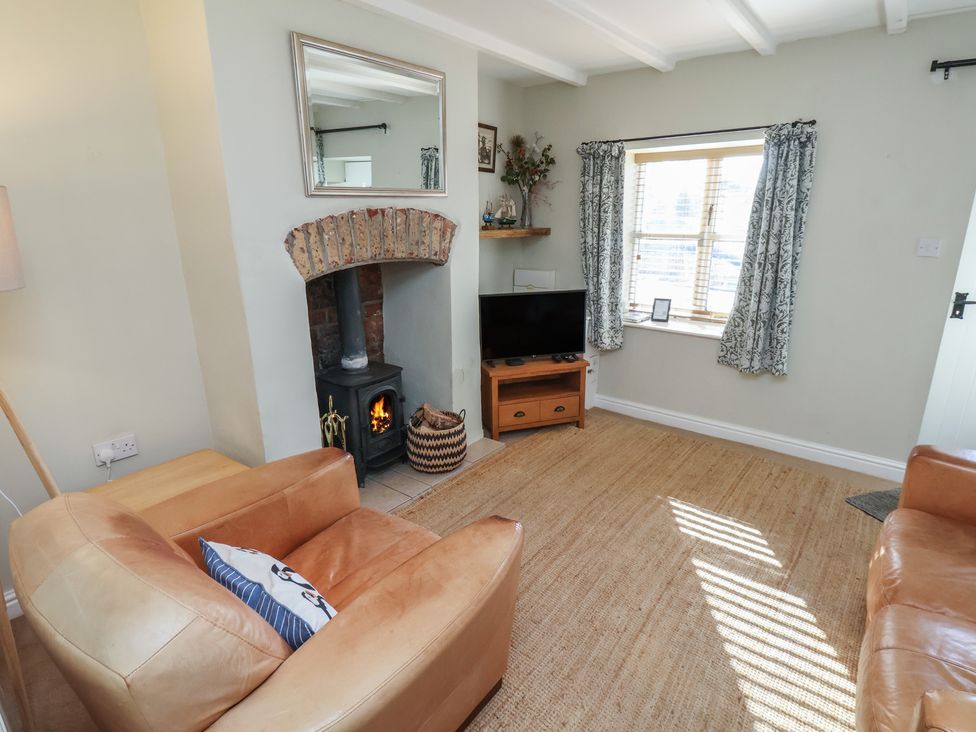 A living room with a fireplace and television at Puffin's Nest