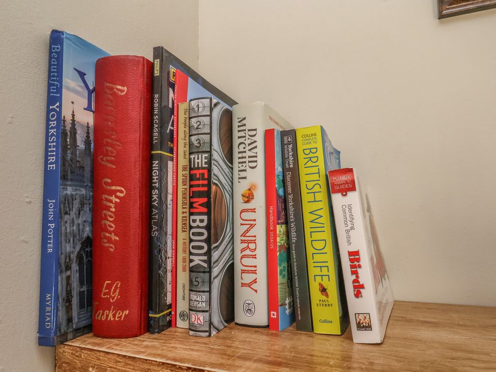 A collection of books on a shelf in a study at Puffin's Nest 