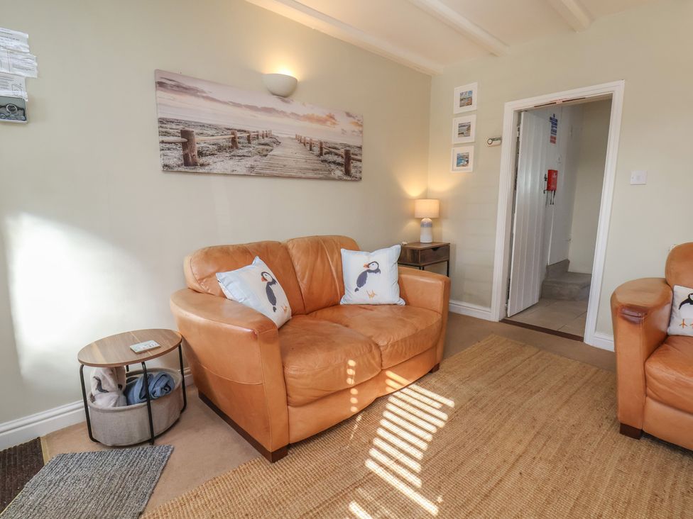 A living room with sofas and a lamp at Puffin's Nest 