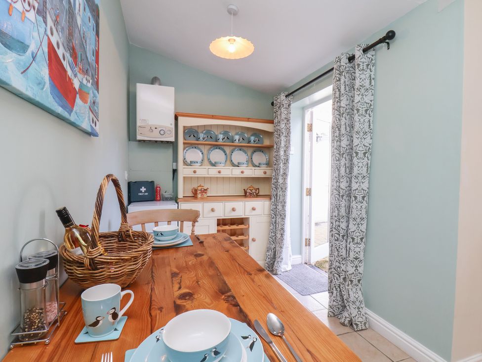 A dining room with a wooden table and chairs at Puffin's Nest