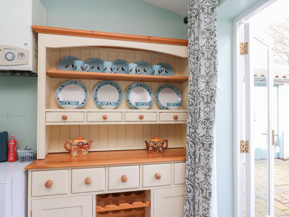 A kitchen with shelves and plates at Puffin's Nest