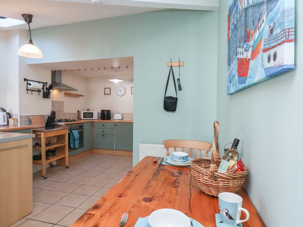 A kitchen with table and chairs at Puffin's Nest