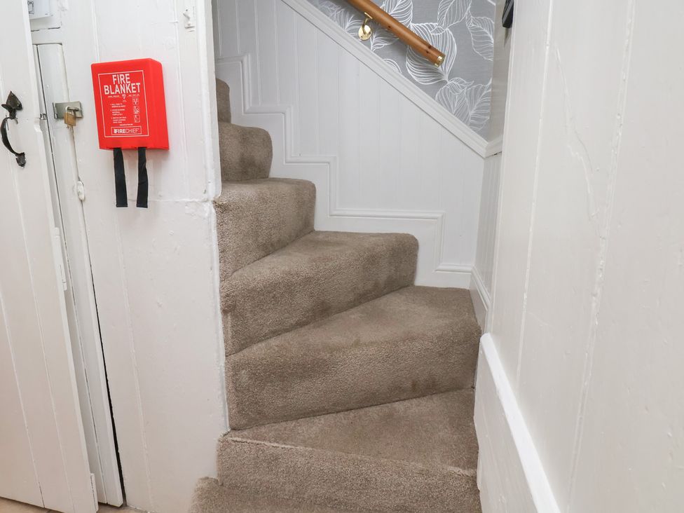 A staircase with a fire blanket at Puffin's Nest