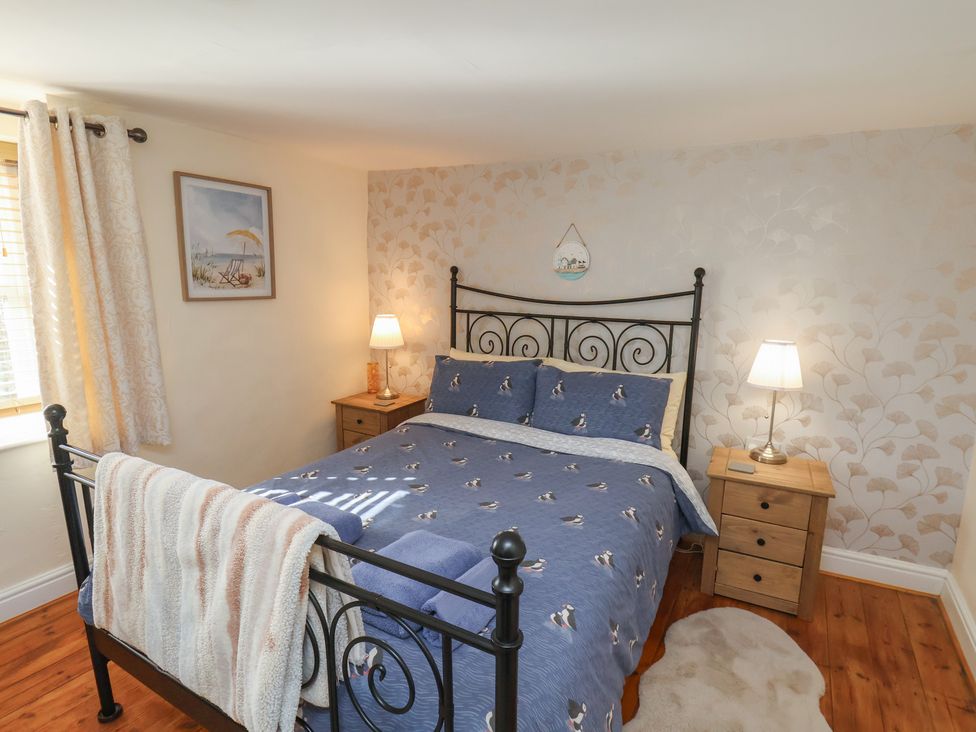 A bedroom with a bed and bedside tables at Puffin's Nest