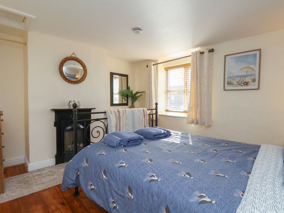 A bedroom with a bed and a window at Puffin's Nest 