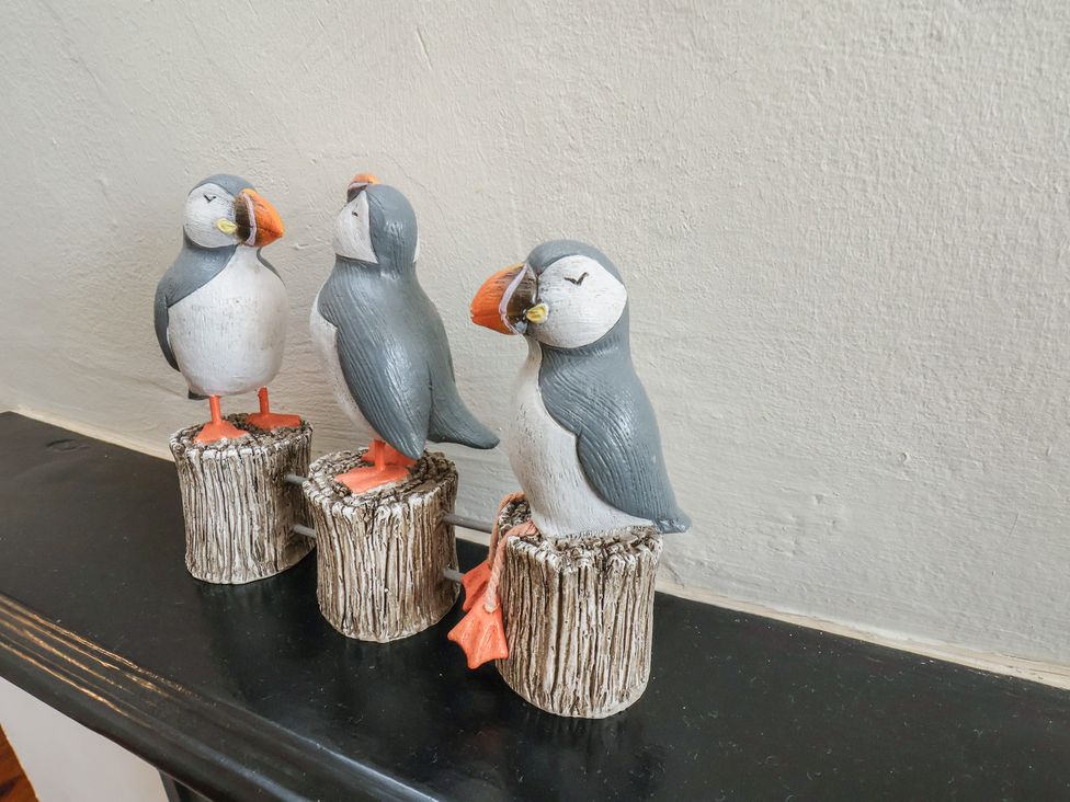 Three puffin figurines on a shelf at Puffin's Nest