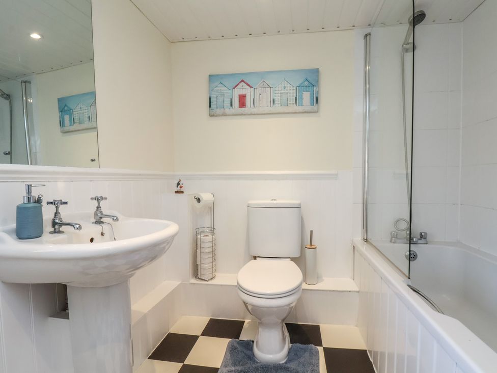 A bathroom with a sink, toilet, and bathtub at Puffin's Nest