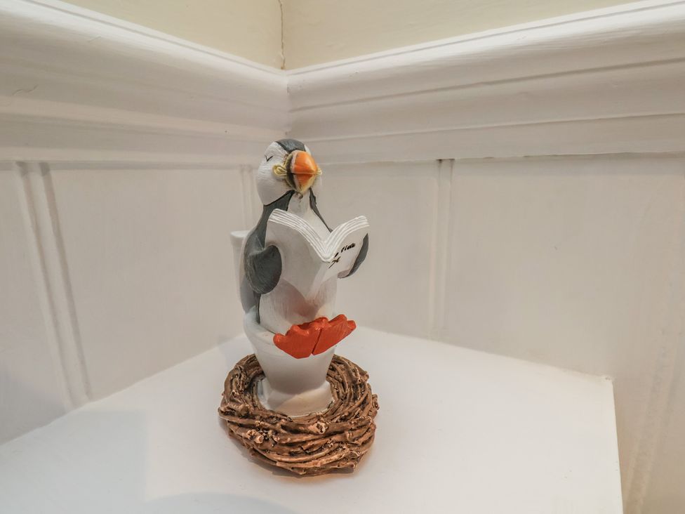 A puffin figurine reading a book on a stand at Puffin's Nest