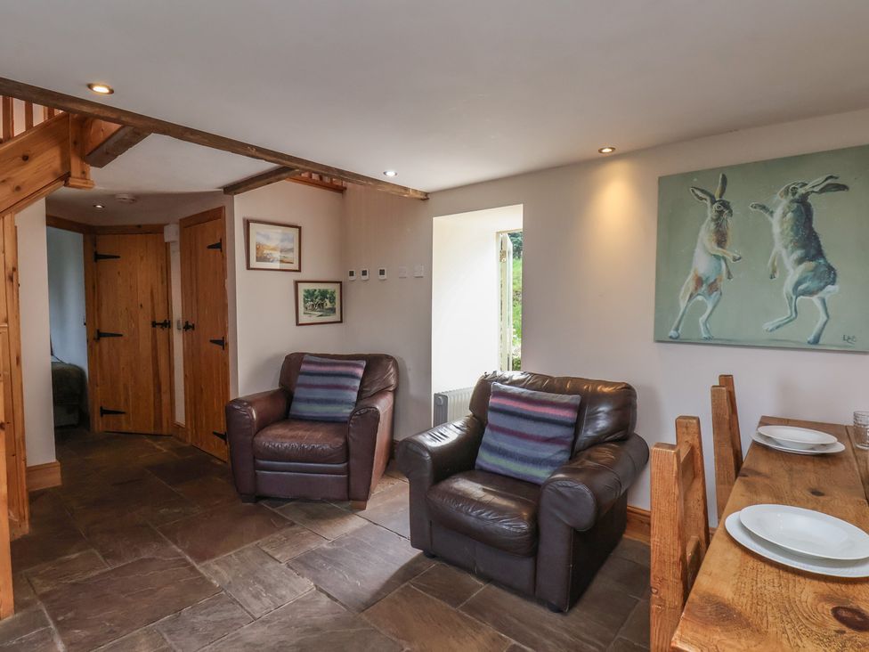 A living room with sofas and a dining table at Horseshoe Cottage Ingleby Greenhow near Great Ayton