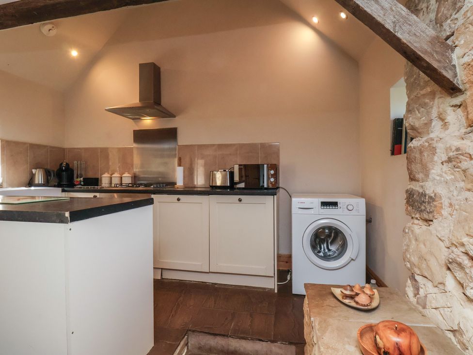A kitchen with appliances and a washing machine at Horseshoe Cottage Ingleby Greenhow near Great Ayton