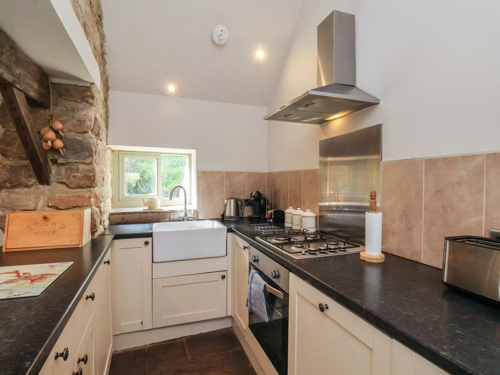 A kitchen with a sink and stove at Horseshoe Cottage Ingleby Greenhow near Great Ayton