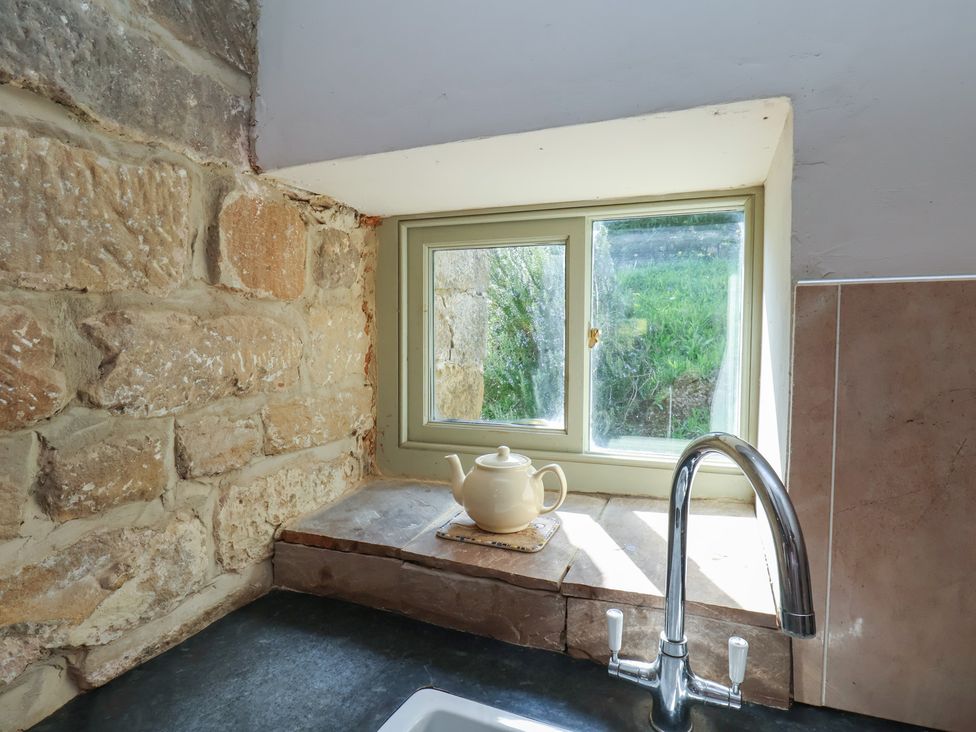 A kitchen with a sink and a window at Horseshoe Cottage Ingleby Greenhow near Great Ayton