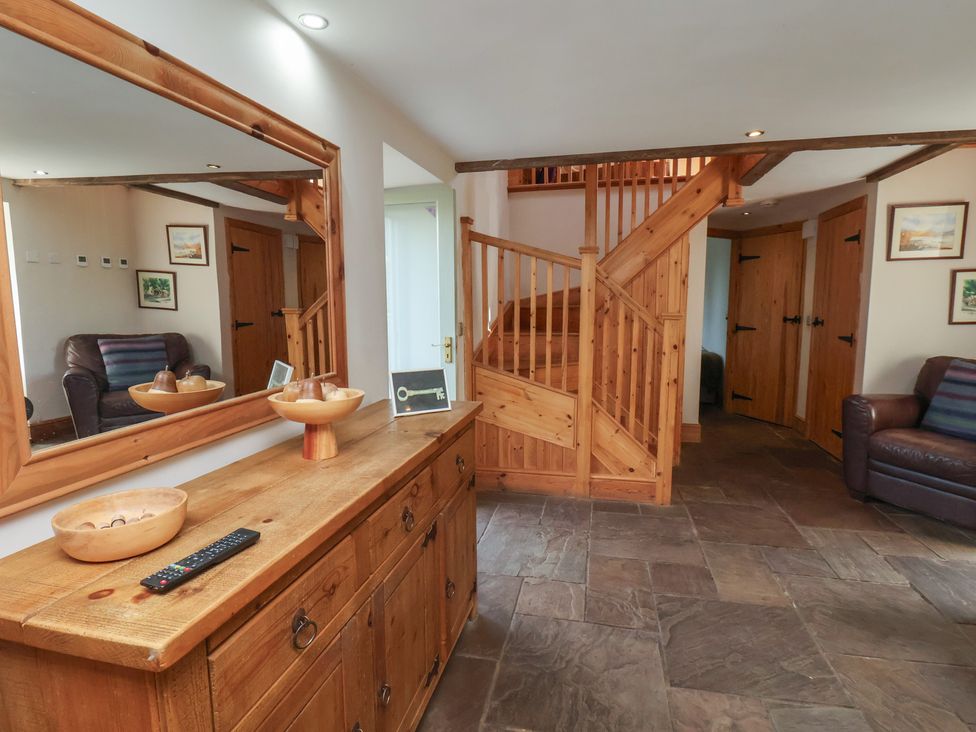 A hallway with a staircase and chest of drawers at Horseshoe Cottage Ingleby Greenhow near Great Ayton