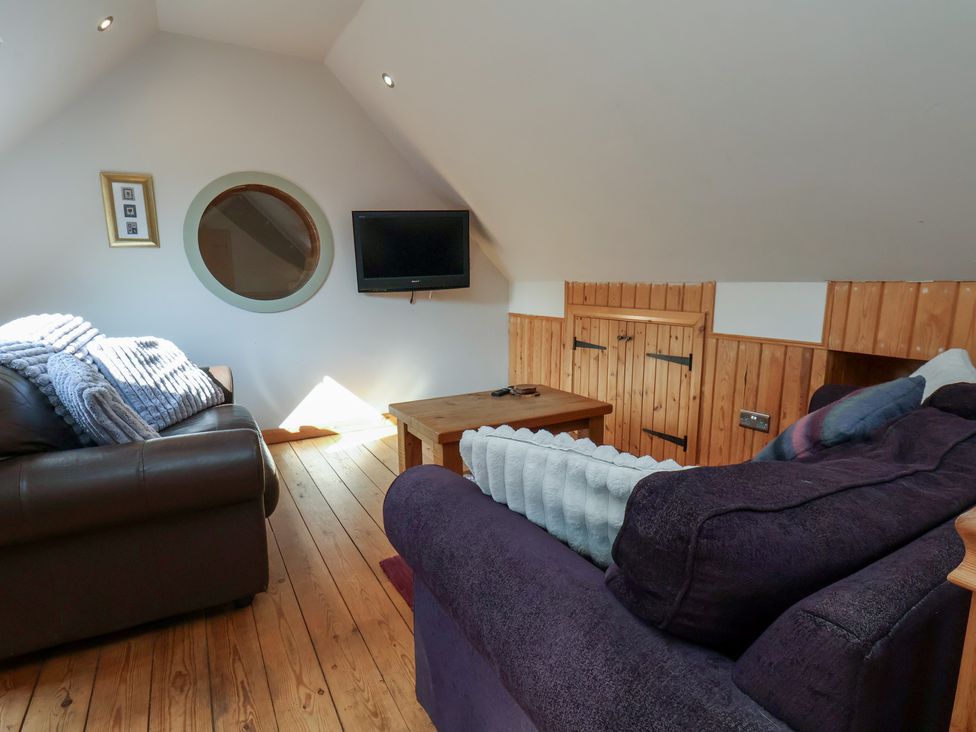 A living room with a sofa and television at Horseshoe Cottage Ingleby Greenhow near Great Ayton