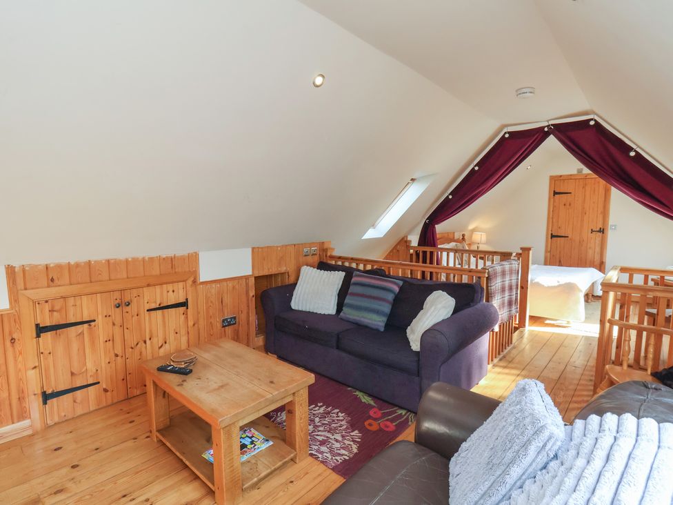 A living room with a sofa and table at Horseshoe Cottage in Ingleby Greenhow near Great Ayton
