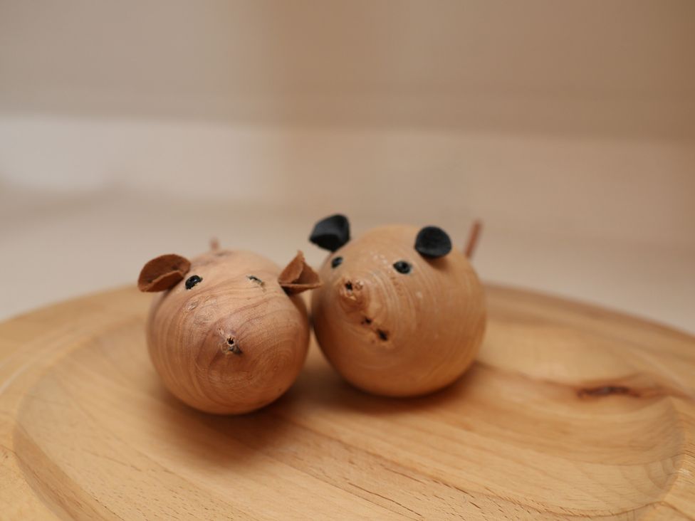 Two wooden pig figures on a wooden surface at Horseshoe Cottage in Ingleby Greenhow near Great Ayton