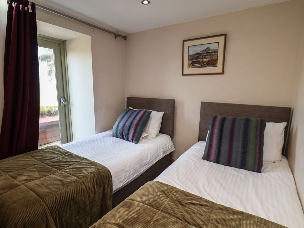 A bedroom with twin beds and a window at Horseshoe Cottage Ingleby Greenhow near Great Ayton