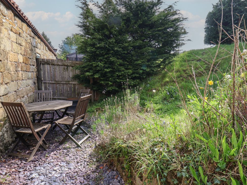 A garden with a table and chairs at Horseshoe Cottage Ingleby Greenhow near Great Ayton