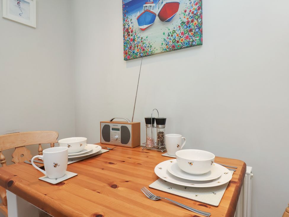 A dining table set with cups and plates at Seashell Cottage