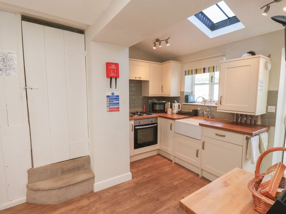 A kitchen with a sink and oven at Seashell Cottage