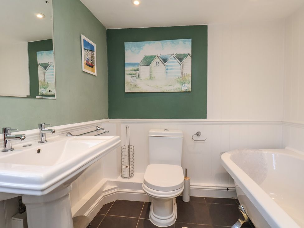 A bathroom with a sink, toilet, and bathtub at Seashell Cottage