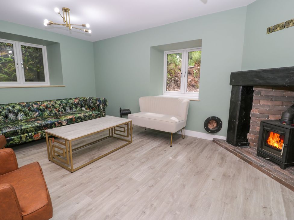 A living room with a sofa and fireplace at Frongoch Old Power House in Dolgellau
