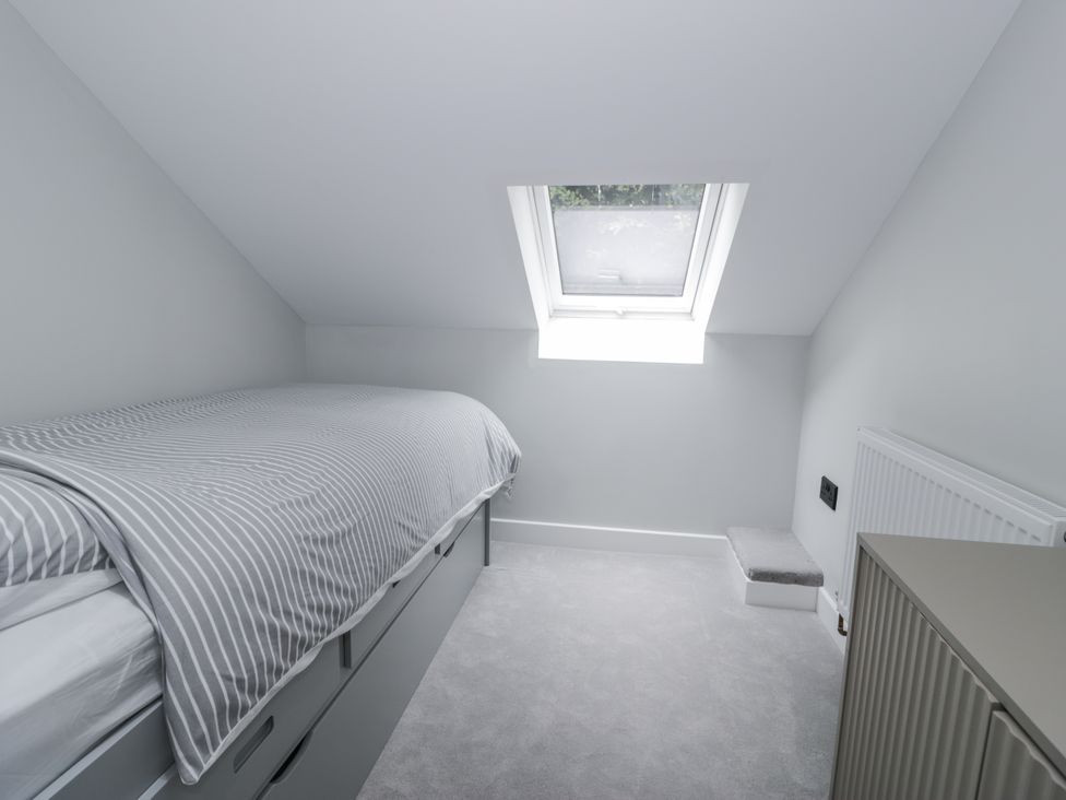 A bedroom with a bed and window at Frongoch Old Power House in Dolgellau