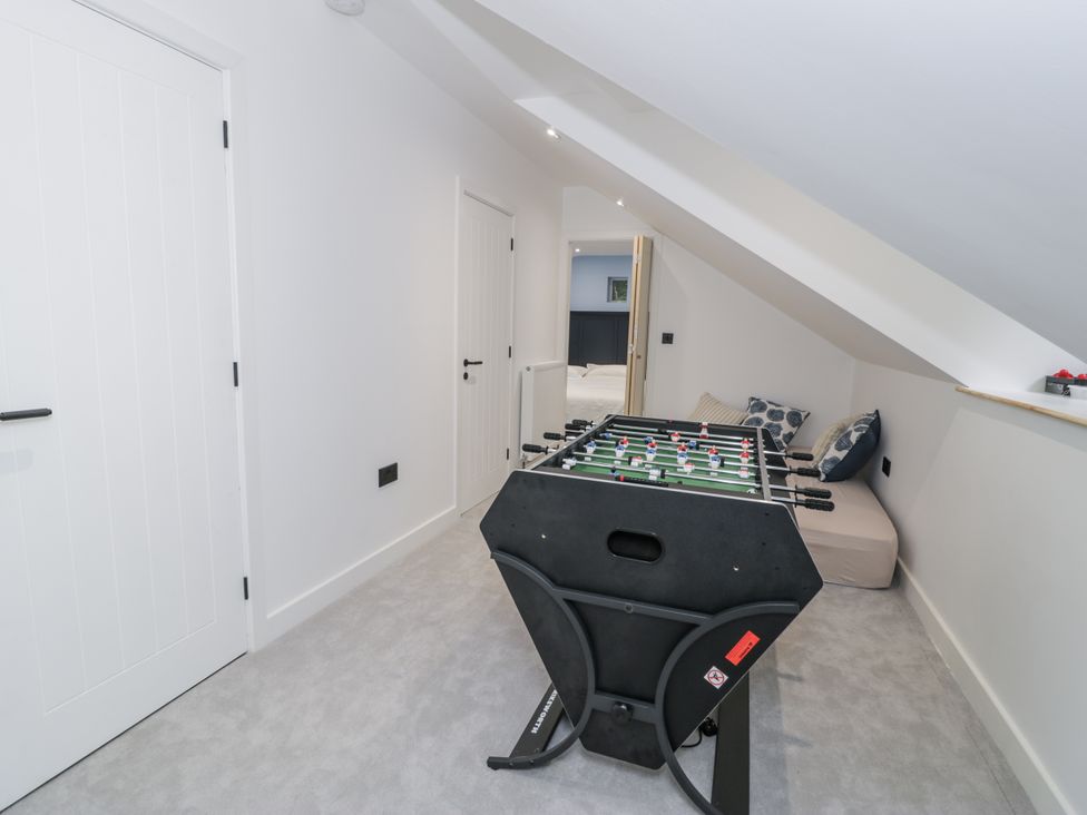 A game room with a foosball table and couch at Frongoch Old Power House Dolgellau