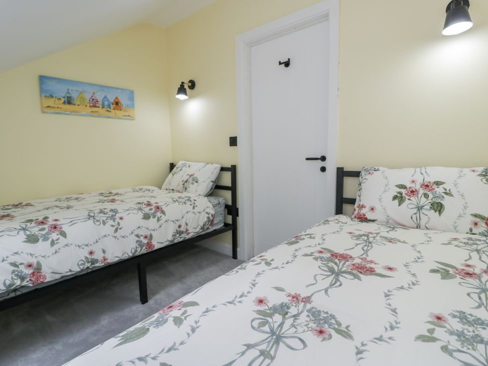 A bedroom with two beds and a door at Frongoch Old Power House Dolgellau