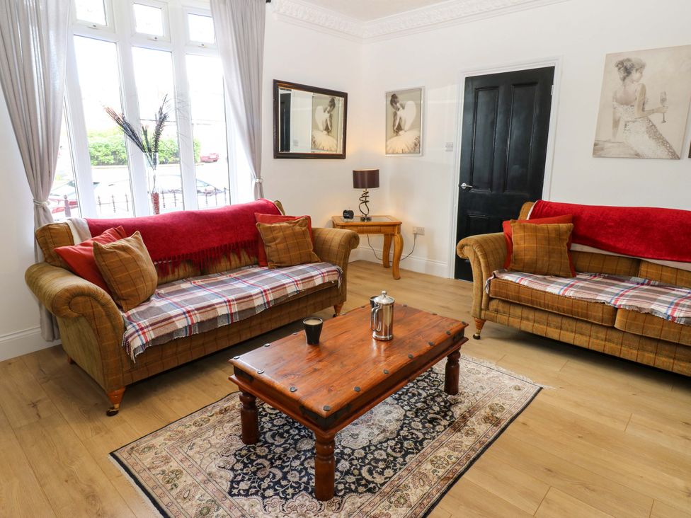 A living room with sofas and a table at 8 Percy Terrace in Whitburn