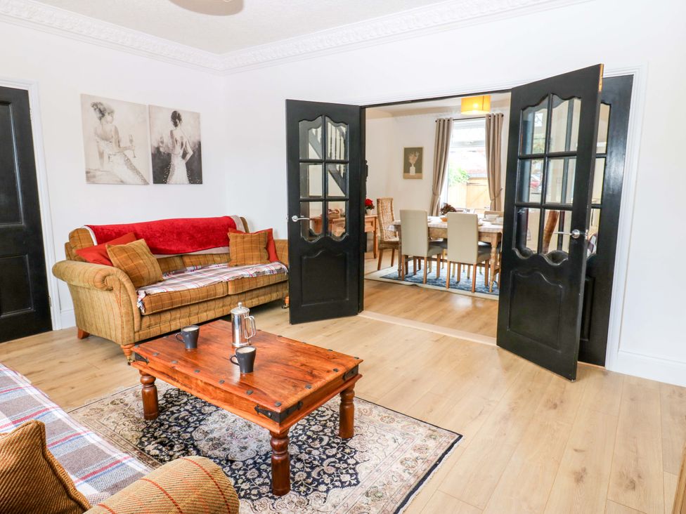 A living room with a sofa and coffee table leading to a dining area at 8 Percy Terrace in Whitburn