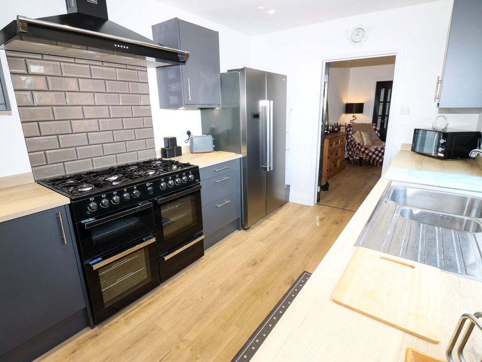 A kitchen with a gas stove and refrigerator at 8 Percy Terrace in Whitburn