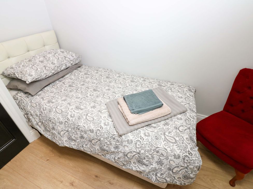 A bed with bedding and towels in a bedroom at 8 Percy Terrace Whitburn