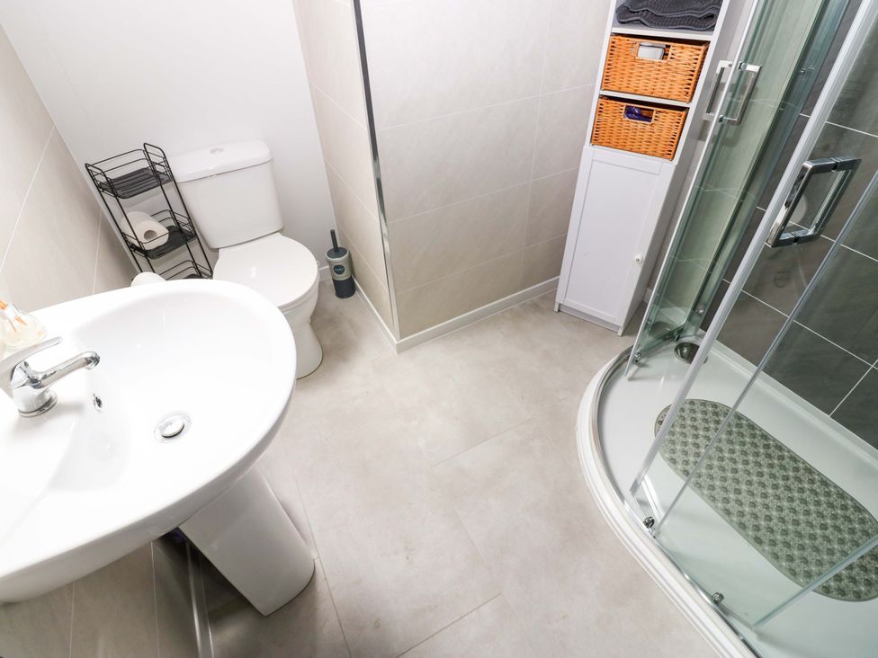 A bathroom with a washbasin, toilet, and shower at 8 Percy Terrace, Whitburn