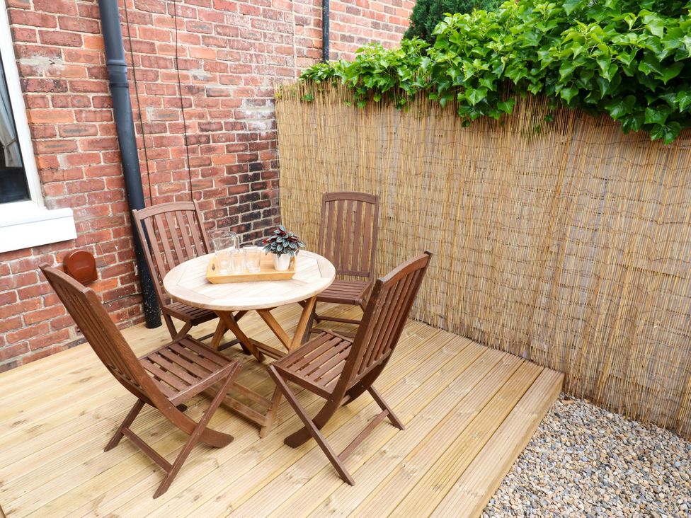A garden with a wooden table and chairs at 8 Percy Terrace Whitburn